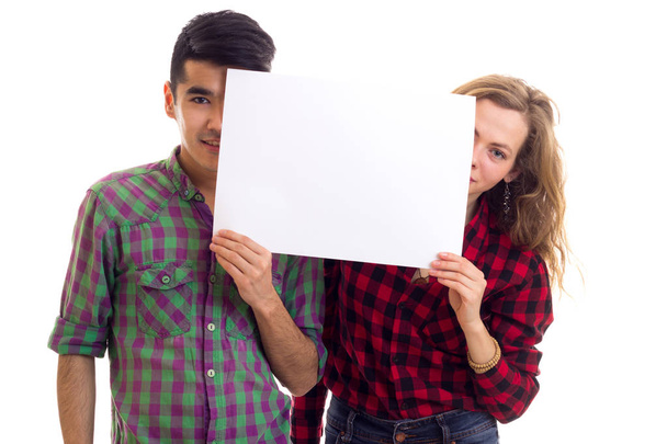 Молодая пара в клетчатых рубашках с плакатом
 - Фото, изображение
