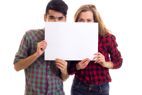 Jeune couple en chemises à carreaux tenant la pancarte
 - Photo, image
