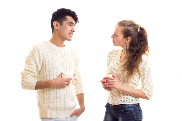 junges Paar hält Tassen in der Hand und redet - Foto, Bild