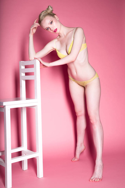 jonge sexy lachende blonde vrouw in lingerie poseren op roze achtergrond, plezier, het dragen van slapende masker. - Foto, afbeelding