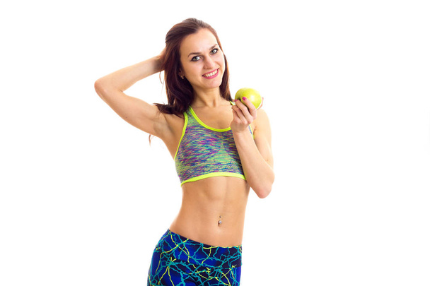 Спортивная женщина держит яблоко
 - Фото, изображение