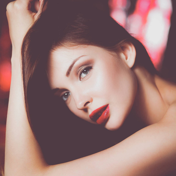 Close-up portrait of beautiful girl with trendy makeup lying - Fotografie, Obrázek