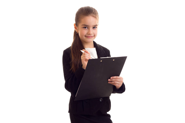 Little girl in black jacket holding pen and folder - Photo, Image