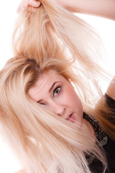 Blonde woman holding her dry hair - Fotoğraf, Görsel