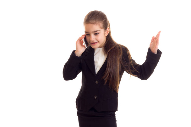 Petite fille en veste noire parlant au téléphone
 - Photo, image