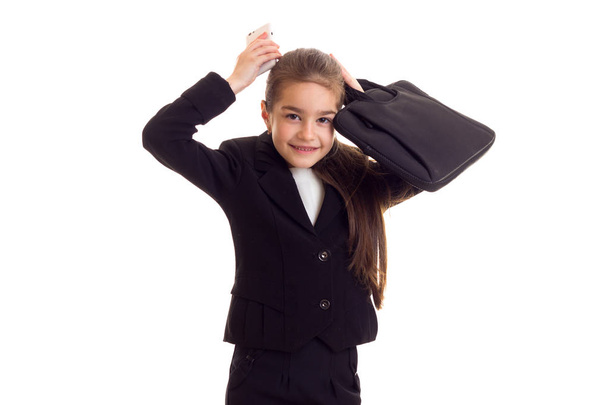 Pieni tyttö musta takki tilalla tutkintotodistus ja älypuhelin
 - Valokuva, kuva