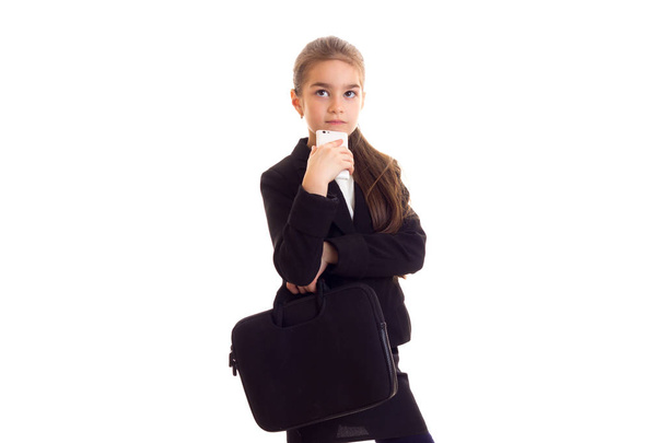 Little girl in black jacket holding diploma and smartphone - Fotografie, Obrázek