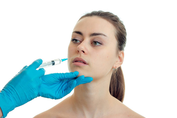 cosmetologist makes prick near the lips a young pretty girl close-up - Foto, immagini