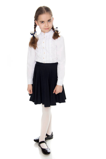 A little girl in a white dress and a dark skirt. - Фото, зображення