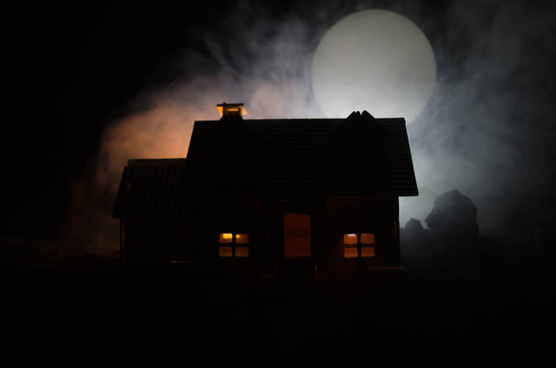 Oud huis met een spook in de maanverlichte nacht of verlaten Haunted Horror House in mist, oude mystic villa met surrealistische grote volle maan. Horror concept - Foto, afbeelding