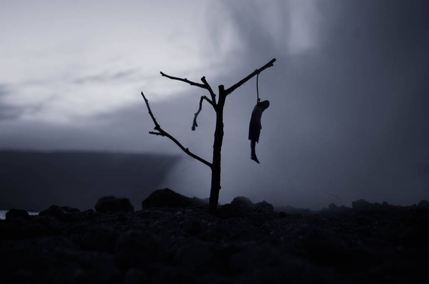 Horror widok dziewczyna powieszony na drzewie w dekoracji samobójstwo wieczorem (nocą). Wykonania kary śmierci lub samobójstwo abstrakcyjną ideą. - Zdjęcie, obraz