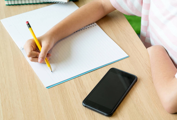 Закройте руку девочке-подростку, обучающейся онлайн с помощью мобильного телефона
 - Фото, изображение