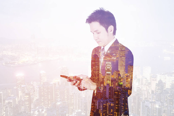 double exposure of business man using smart phone with city back - Photo, Image