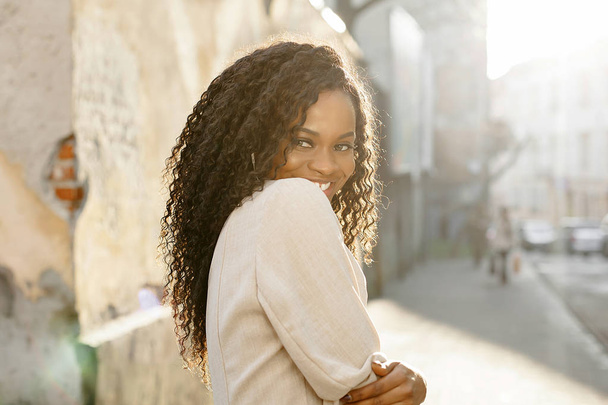 Portrait of shy beautiful black girl with long curly hair. - Фото, зображення