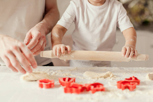 Close up shot of adult and childs hands making a dough for baking cookies. - Photo, image