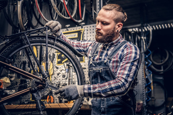 Bicycle mechanic in a workshop - Fotoğraf, Görsel