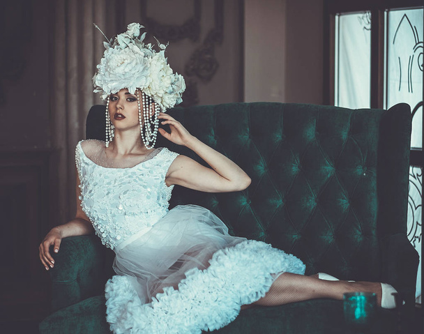 Beautiful bride sits on a chair. Luxury palace. - Foto, afbeelding