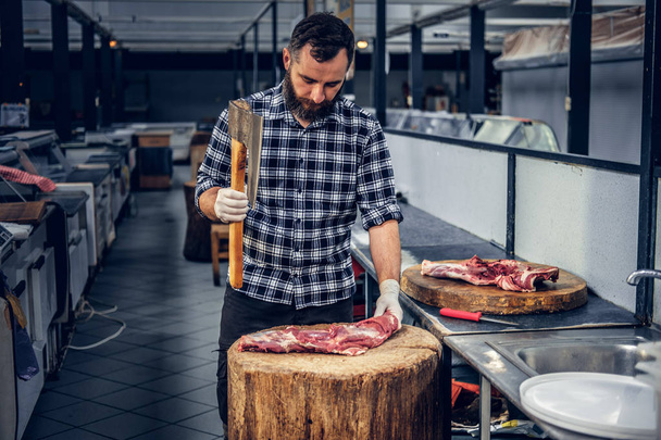 Bearded butcher with the bloody axe - Photo, Image