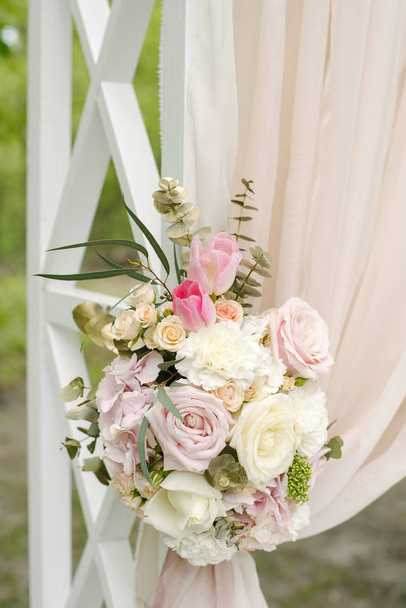 Bellissimo arco nuziale decorato con stoffa beige e fiori
 - Foto, immagini