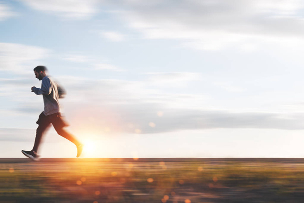 Athlete trains and runs at sunset on outdoors in the park. Motion blur effect - Photo, Image