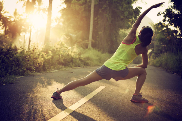 Młoda kobieta runner rozgrzewanie - Zdjęcie, obraz