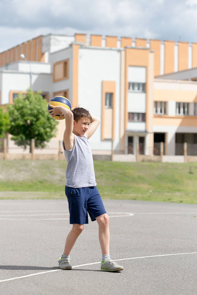 Подросток в футболке и шортах, играющий с мячом
 - Фото, изображение