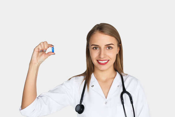 Woman posing with pill in hand - Photo, image