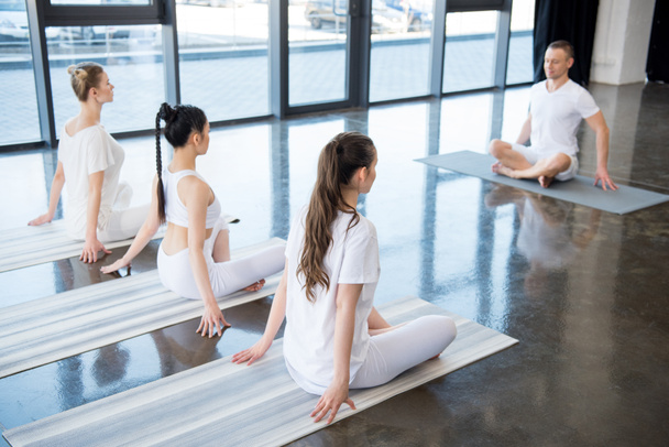 women sitting in lotus pose with instructor - Photo, Image