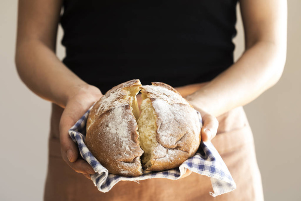 Female hand holding hot freshly baked bread - Foto, Imagem
