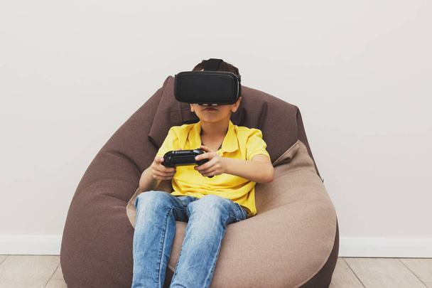 Poika pelaa peliä virtuaalitodellisuus lasit sisätiloissa
 - Valokuva, kuva