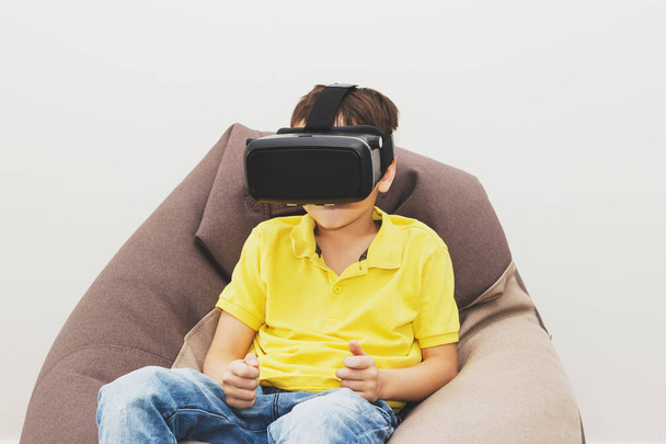 Garçon joue jeu avec des lunettes de réalité virtuelle à l'intérieur
 - Photo, image