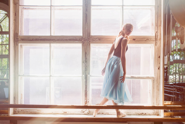 Μπαλαρίνα χορεύει μπροστά από ένα μεγάλο παράθυρο - Φωτογραφία, εικόνα