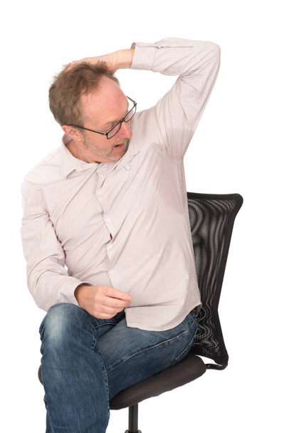 Hombre mira parche de sudor en camisa
 - Foto, Imagen
