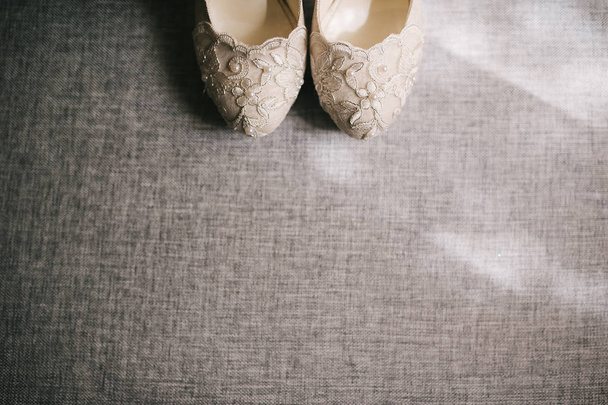 Elegantní a stylové svatební boty zdobí květy, hnědé pozadí - Fotografie, Obrázek