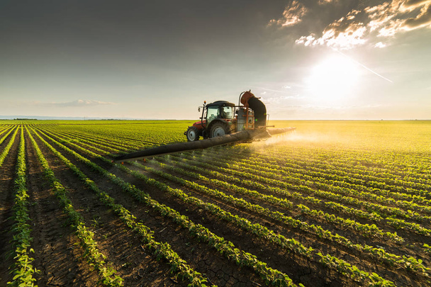 Trator pulverizando campo de soja na primavera
 - Foto, Imagem