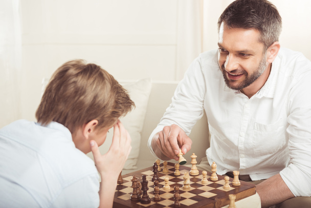 chico jugando ajedrez con padre
 - Foto, Imagen