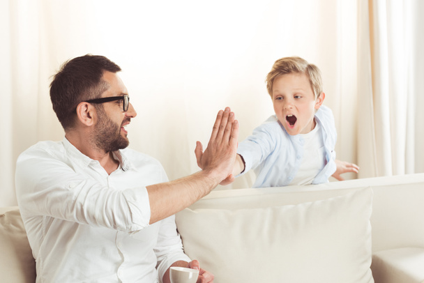 father giving high five to son - Foto, Bild