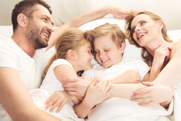 Szczęśliwa rodzina kaukaski, leżąc w łóżku - Zdjęcie, obraz