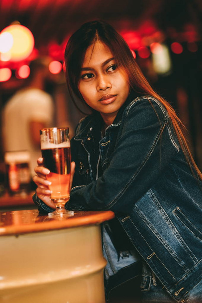 Młoda, piękna kobieta, picia piwa w barze - Zdjęcie, obraz