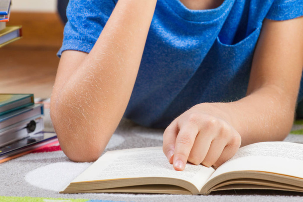 Ребенок положил руку на книгу во время чтения книг
. - Фото, изображение