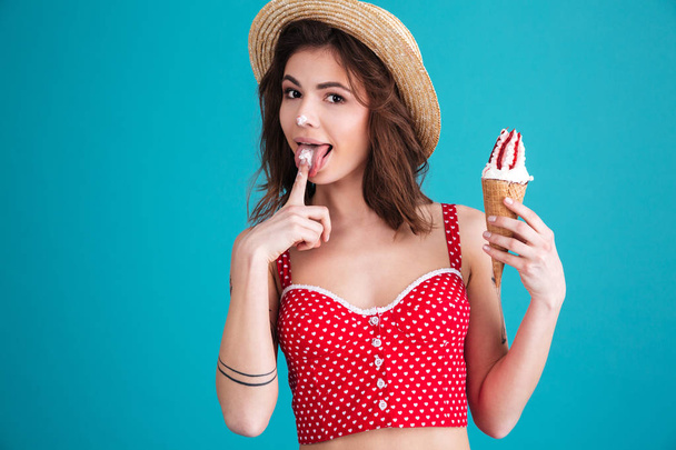 Beautiful young woman with ice-cream looking at camera - 写真・画像