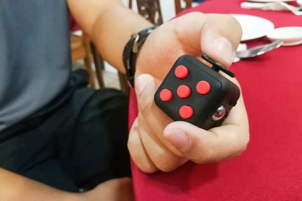 Persona de la mano disfrutar, jugar, aliviar con el cubo de fidget
 - Foto, Imagen