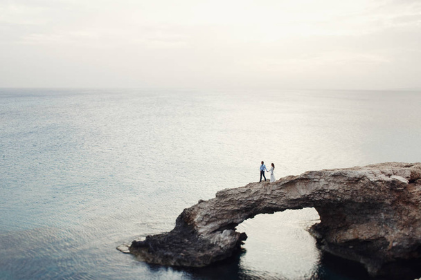 Wedding couple walks over the natural stone bridge - Foto, Imagem