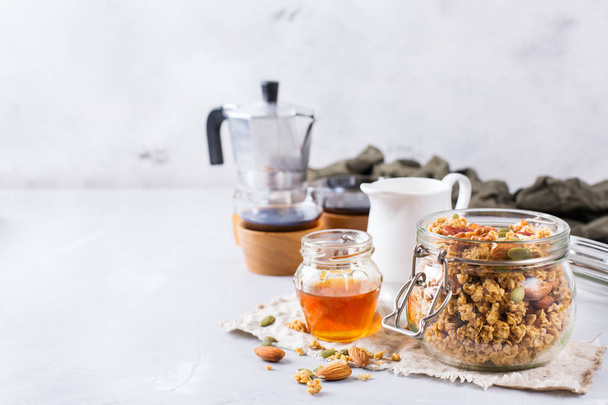 Aamiainen musta kahvi mysli mysli mysli hunaja pähkinät maito
 - Valokuva, kuva