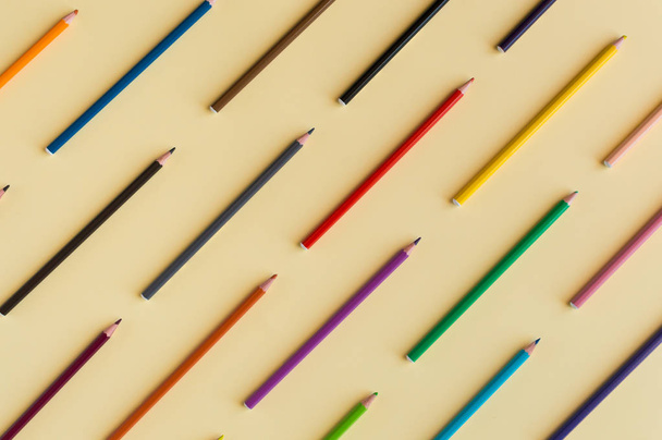 Fondo colorido con muchos lápices de colores pasteles alineados en amarillo
 - Foto, Imagen