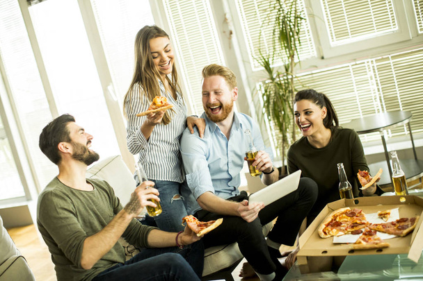 Amigos comiendo pizza en el interior moderno
 - Foto, imagen