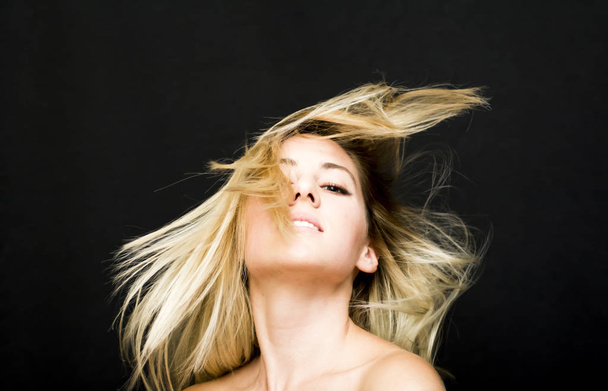 Retrato de una hermosa mujer sacudiendo su cabello en el backgrou negro
 - Foto, imagen