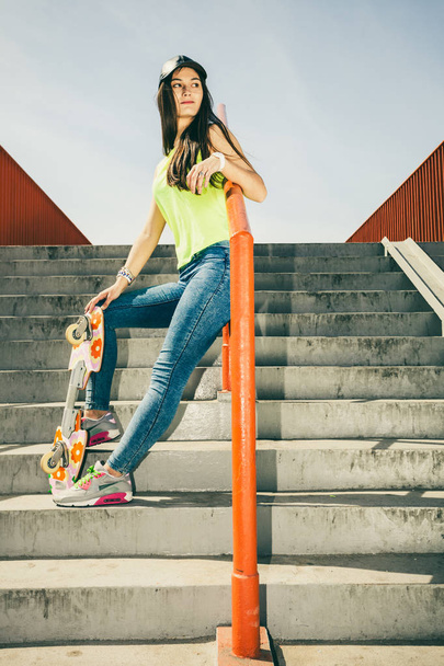 Girl on stairs with skateboard. - Zdjęcie, obraz