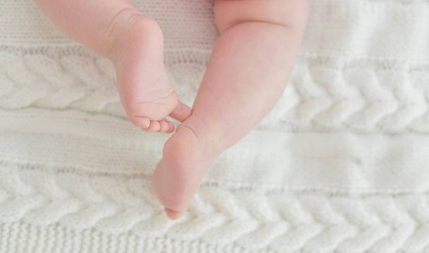 Newborn Baby legs on the bed - Фото, изображение