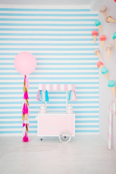 Gyermek zóna édességek: nyalókák, fagylalt, macarons, léggömb, és candy bar. Gyerekek szoba kék csíkos háttér - Fotó, kép